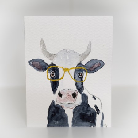 A greeting card featuring a painting of a black and white cow wearing gold glasses.