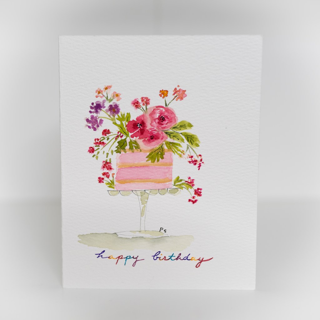 A greeting card featuring a painting of a pink cake with flowers on top.