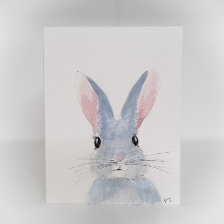 A greeting card featuring a painting of a grey bunny with pink ears.