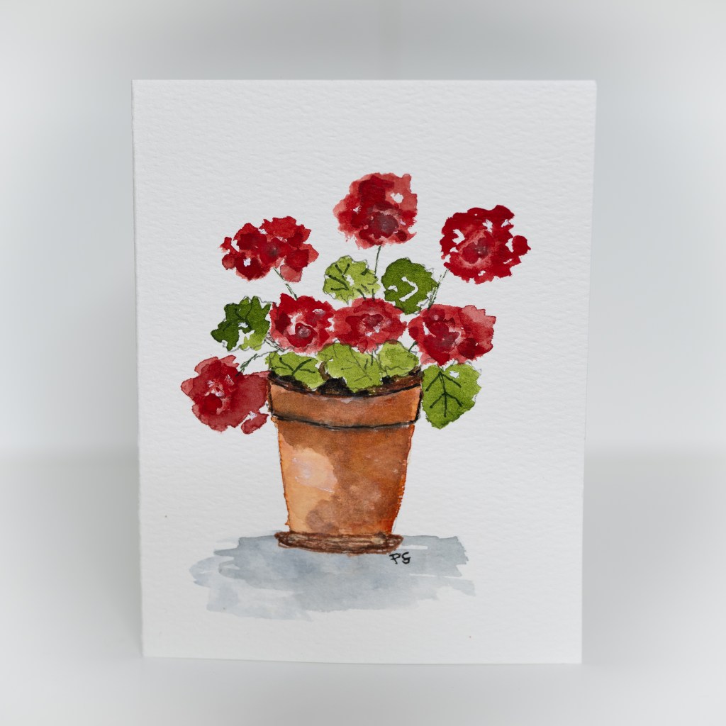 A greeting card featuring a painting of red geraniums in a brown pot.