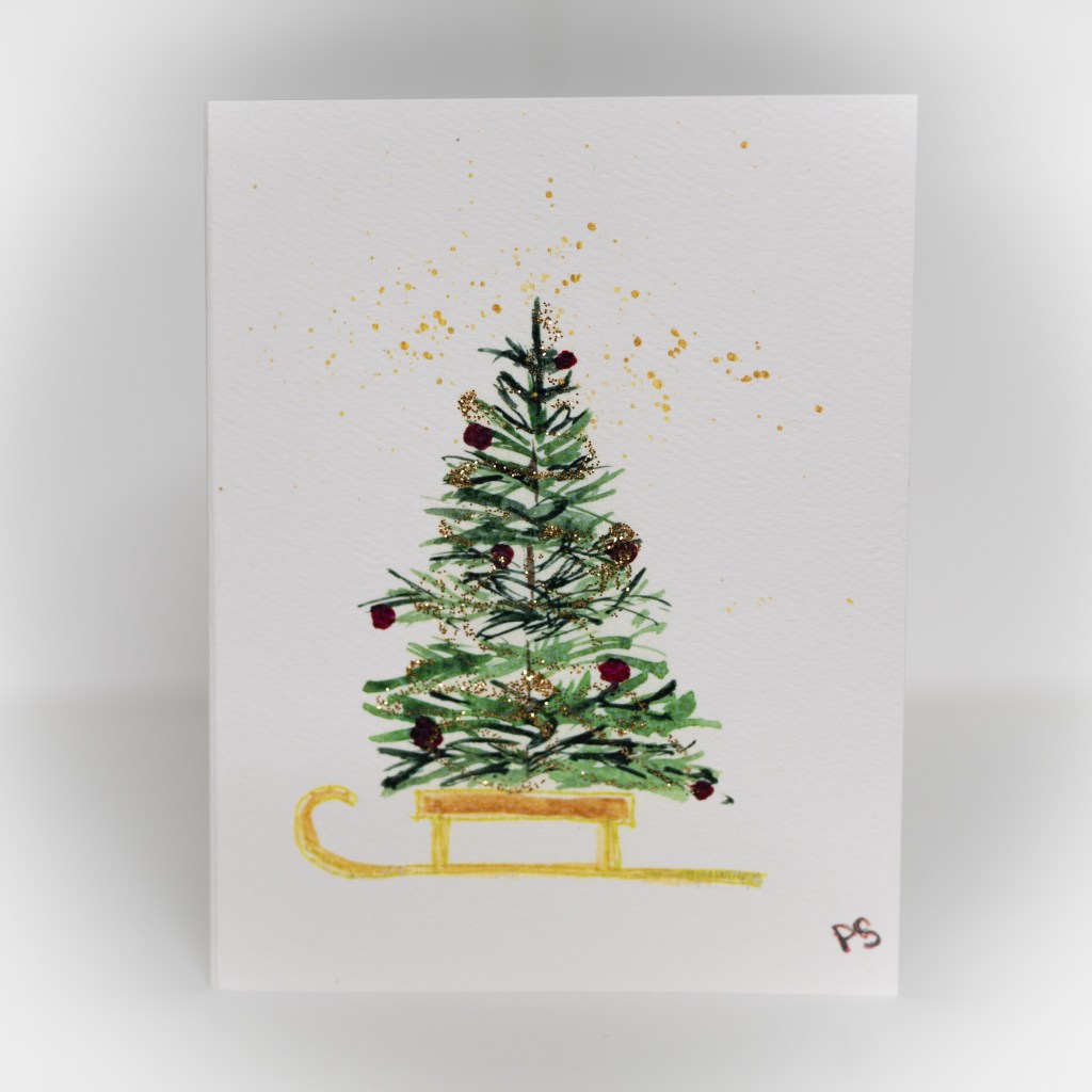 A greeting card featuring a painting of a decorated tree on top of a gold sled.