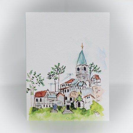 A greeting card featuring a painting of a village with a tall church tower.